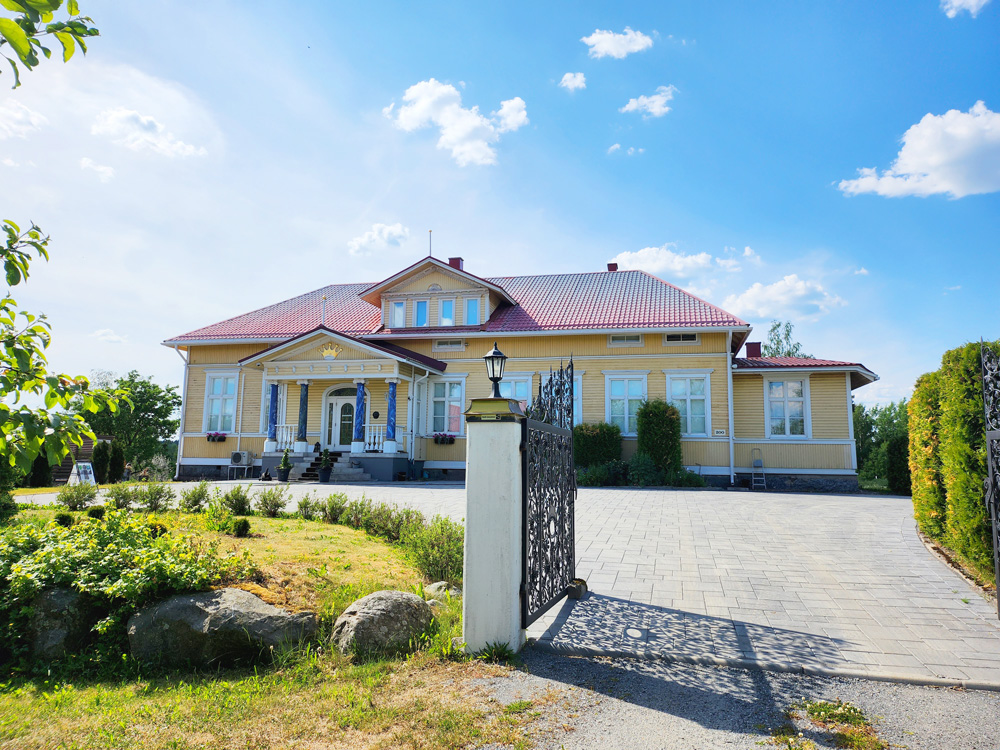 iso villarakennus, valurautainen ajoportti, kesäpäivä, sininen taivas, nurmikkoa