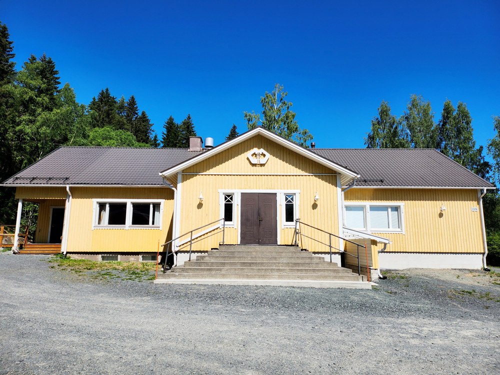 keltainen puurakennus, kiviportaat, sininen kesätaivas, lämmin kesäpäivä, puita