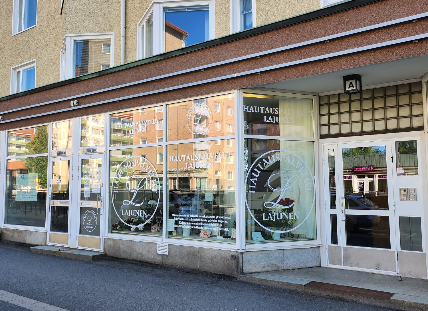 kivijalkamyymälä, hautaustoimiston kyltit, ikkunaa, sisäänkäynti katutasosta