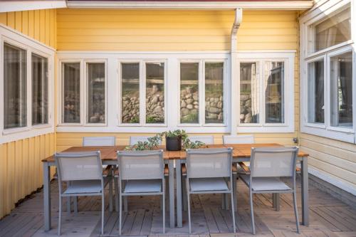 terassin pöytä ja tuoleja, puutalon edustalla